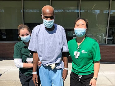 Kimberly Diggs walking with his therapists.