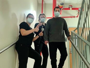 Sean Cestone and two of therapists on the hospital stairs.